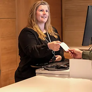 Incheckning i receptionen på Spar Hotel Gårda i Göteborg. Receptionist ger gäst nyckelkortet.