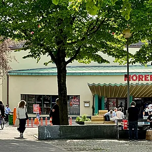 Folkliv på ett grönskande och somrigt Stigbergstorget i Majorna i Göteborg.