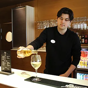Bartender häller upp ett krispigt vitt vin i baren på Spar Hotel Majorna i Majorna Göteborg.